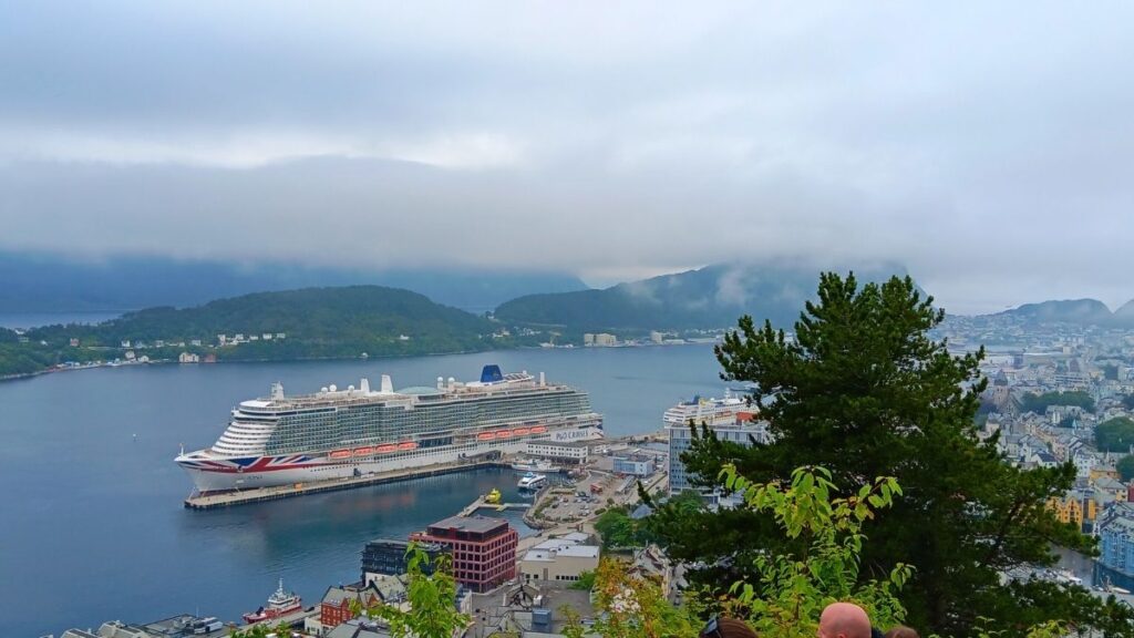 A photo of the P&O Iona docked at Ålesund, Norway on a misty day. This was taken from a view point looking down at the ship and land.