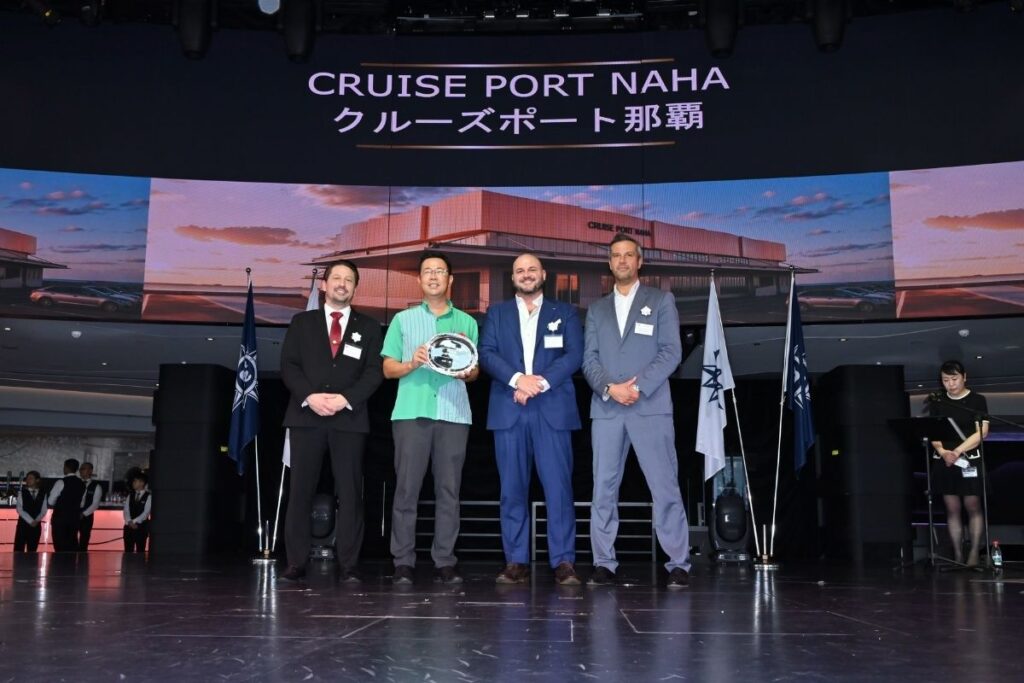 Representatives from Royal Caribbean, MSC Cruises, and Okinawa pose at the Cruise Port Naha groundbreaking ceremony in Japan, with a rendering of the new cruise terminal behind them.