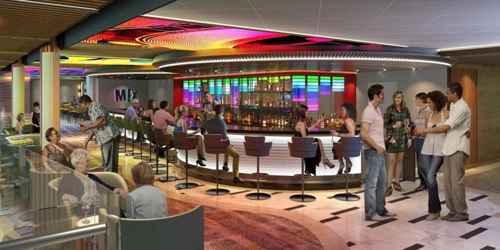 Guests socializing around the colorful Mix bar aboard Carnival Festivale cruise ship.