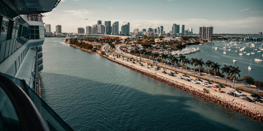 Traffic backs up on the PortMiami causeway with the Miami skyline ahead, seen from a cruise ship.