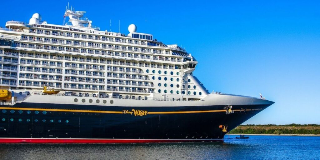 Disney Wish cruise ship side view at sea, with the ship’s name visible on the hull.