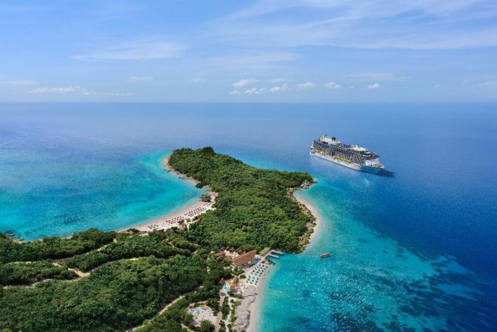 Aerial view of Royal Beach Club Lelepa in Vanuatu, surrounded by turquoise water with a Royal Caribbean cruise ship offshore.