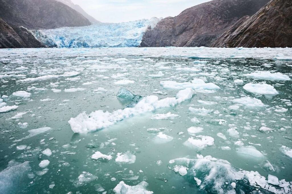 Floating ice in front of Sawyer glacier in Tracy Arm Fjord in Alaska, showing the icy conditions cruise ships can face on scenic glacier routes.