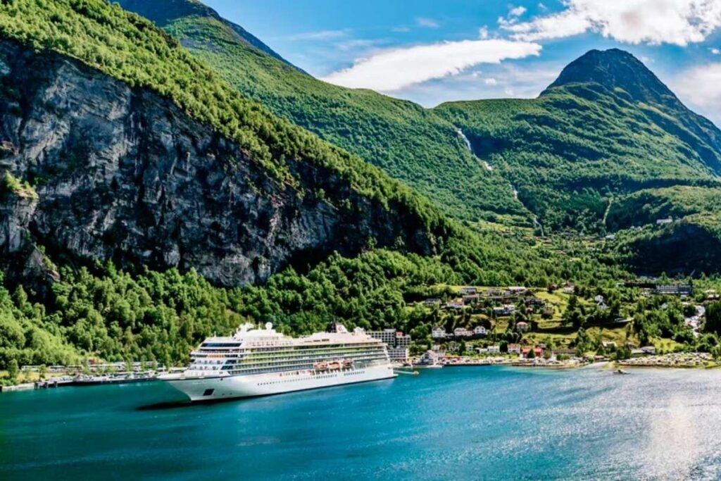Rendering of Viking Astrea cruise ship sailing through a Norwegian fjord surrounded by steep green mountains.