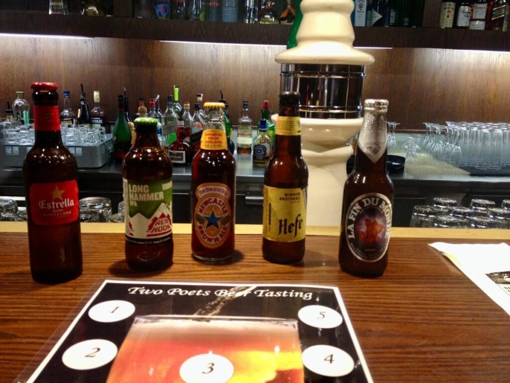 Beer tasting setup with five bottles lined up on a cruise ship bar.