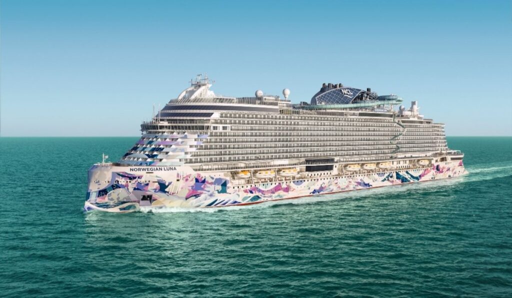 Norwegian Luna cruise ship sailing on open water, showing its colorful hull artwork and tiered balcony decks.