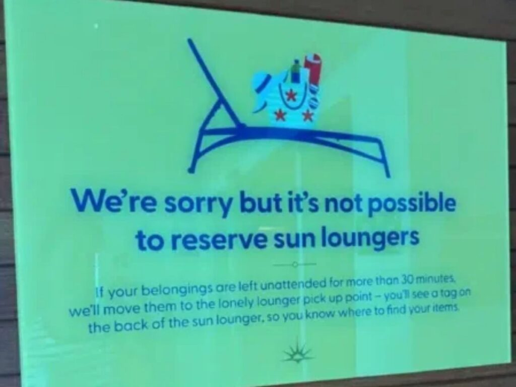 Pool deck sign says loungers aren’t reservable and unattended belongings may be moved after 30 minutes.