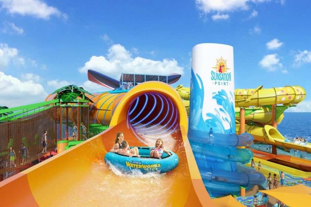 Carnival Tropicale Sunsation Point waterpark with colorful waterslides and guests riding a raft slide.