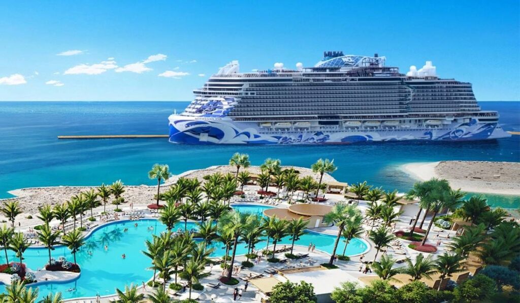 Norwegian Cruise Line ship docked at Great Stirrup Cay beside the new pier, with the island’s lagoon pool and palm trees in the foreground.