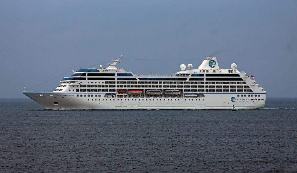 Azamara cruise ship viewed from the side sailing across open ocean under a clear sky.