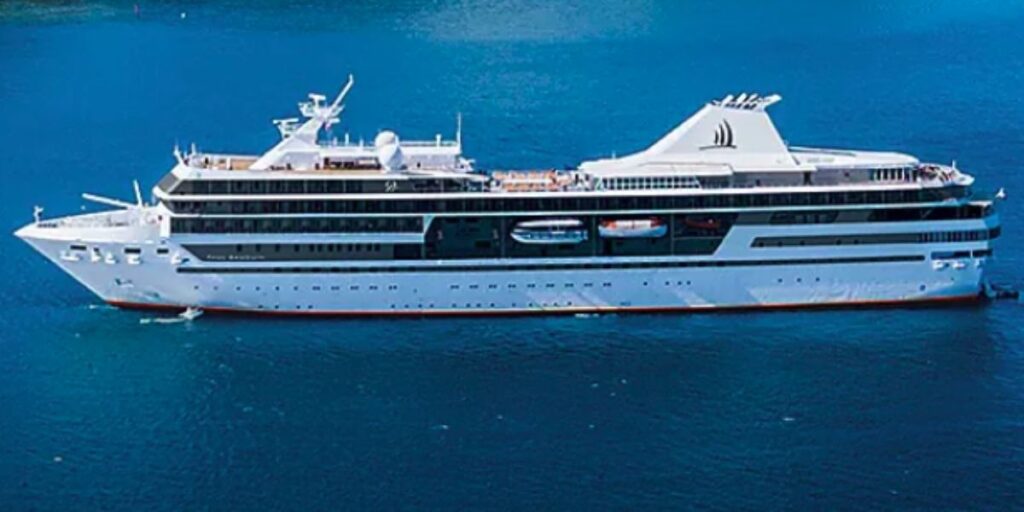 Paul Gauguin cruise ship viewed from the side sailing on calm blue water.