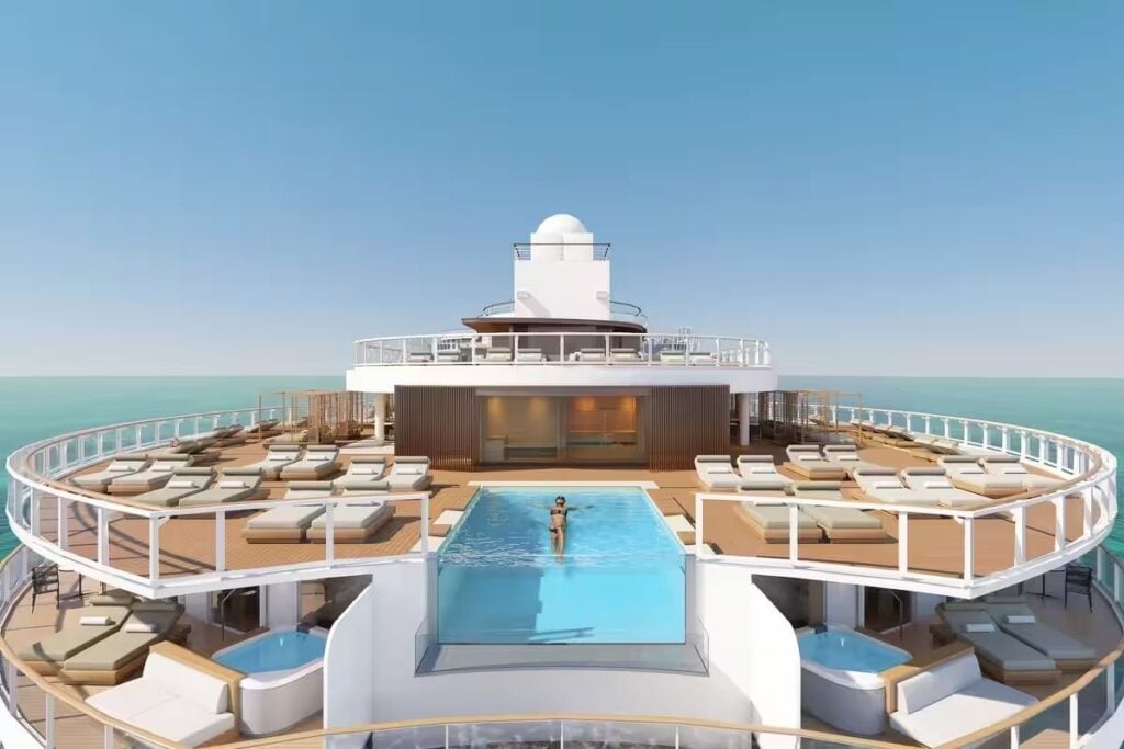 The Haven's private sundeck aboard Norwegian Bella, featuring an infinity pool overlooking the ocean, two hot tubs, and surrounding lounge chairs.