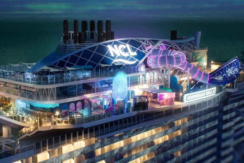 Nighttime rendering of Ocean Heights aboard Norwegian Bella, showing illuminated waterslides, colorful LED lighting, and upper-deck attractions.
