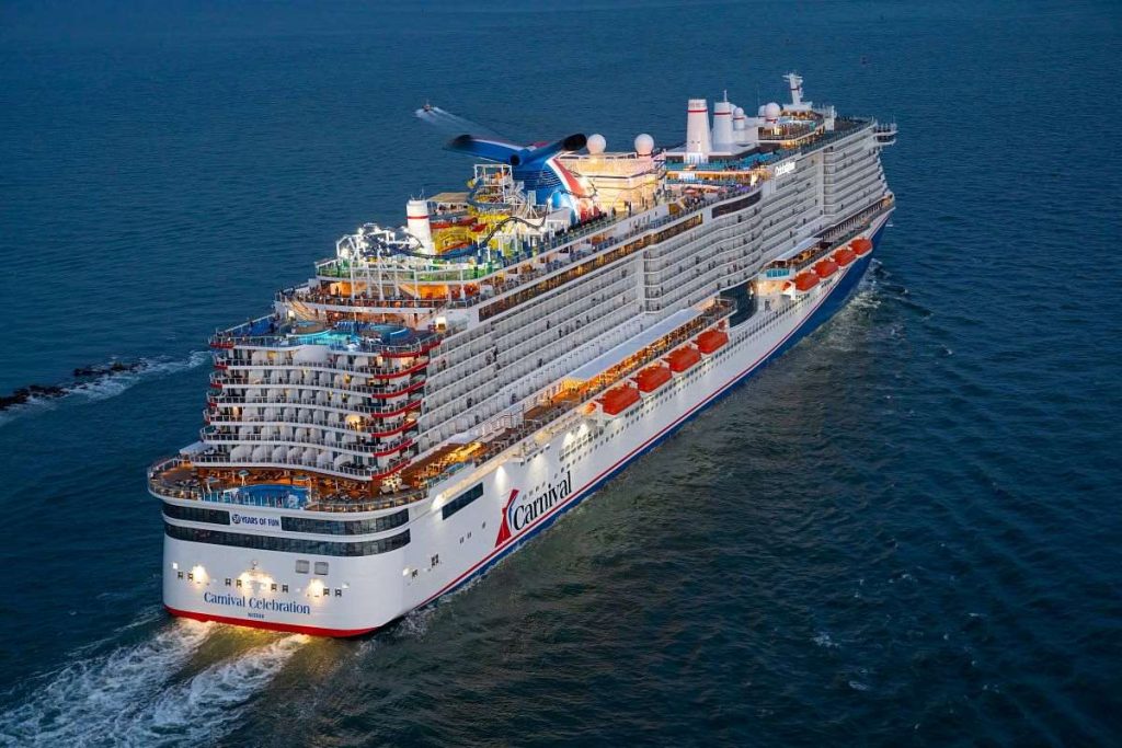 Carnival Celebration cruise ship captured in an aerial shot as it navigates the waters near Miami, displaying the ship's extensive decks and leisure amenities.