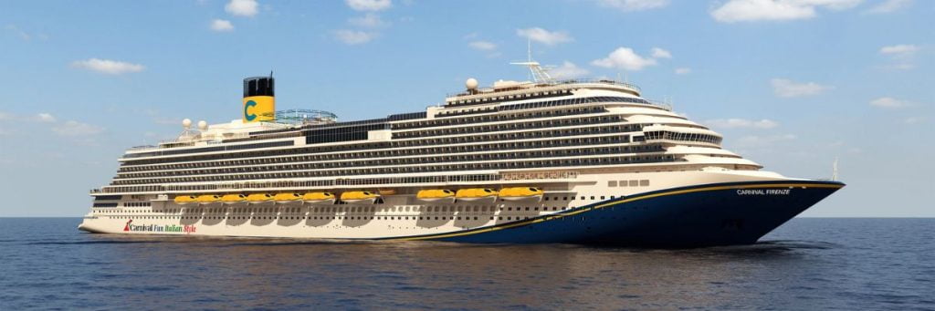 A large cruise ship, the Carnival Firenze, majestically sails on a calm blue ocean under a clear sky.