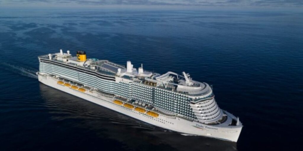 The Costa Toscana cruise ship cutting through tranquil sea waters, showcased in a stunning aerial view that highlights its multiple decks, elegant design, and the signature yellow funnel with the Costa logo.
