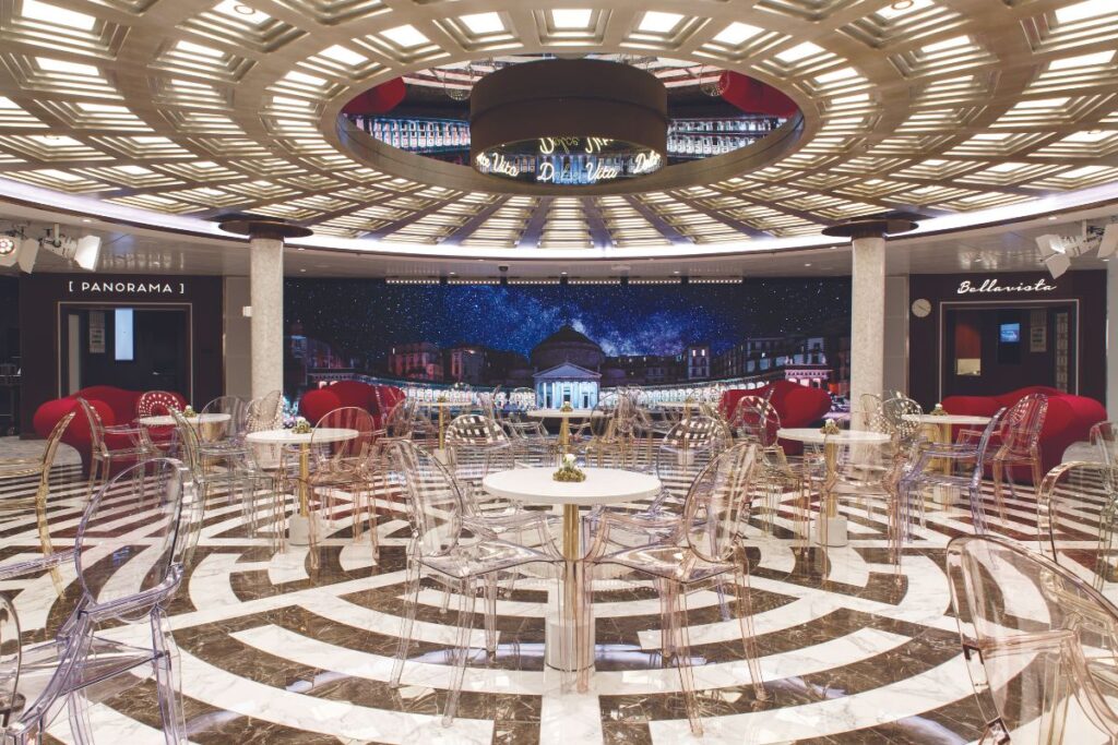 Costa cruise ship indoor dining room with an elegant vibe with its transparent tables and chairs and wonderful interior design