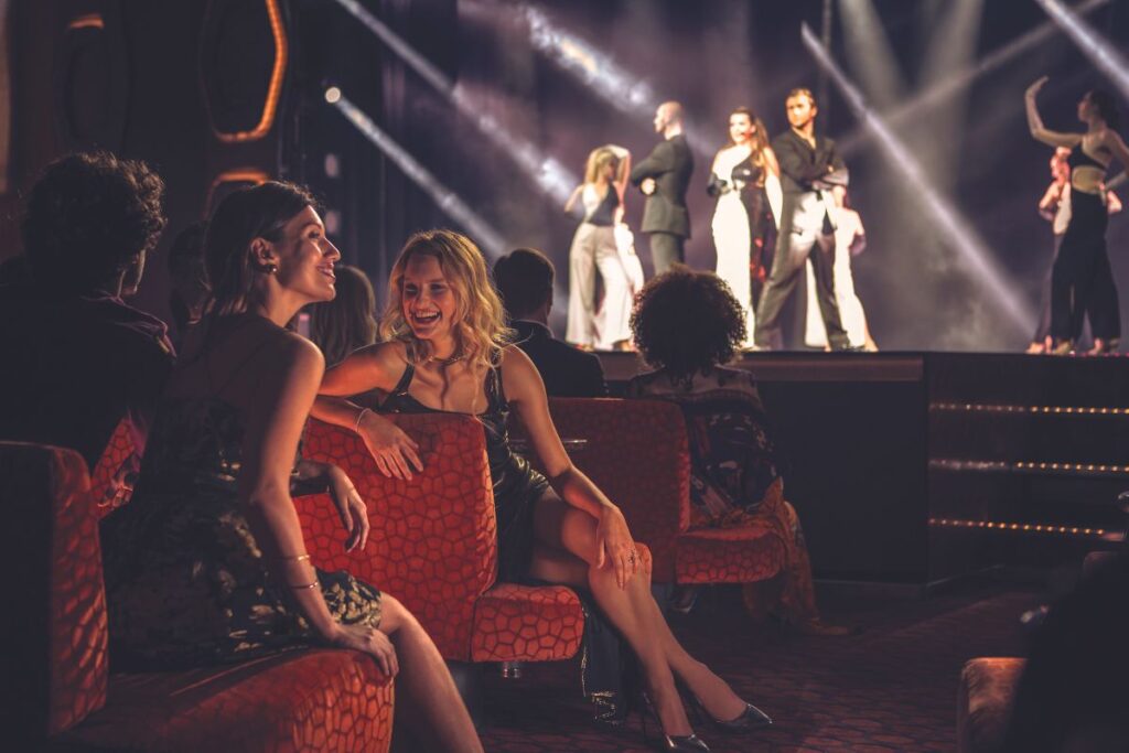 Ladies happily chatting showing their enjoyment on the show that they're watching onboard