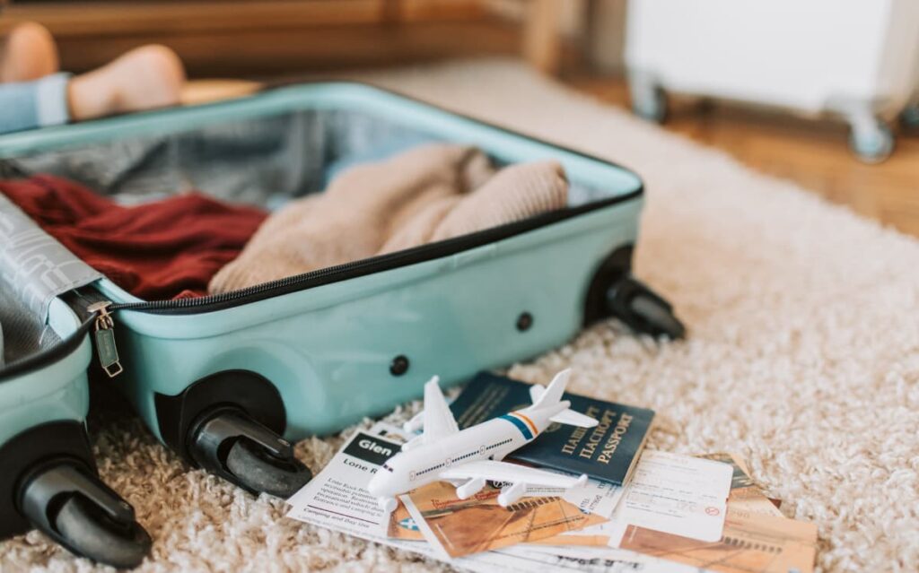 Open suitcase with clothing and fashion accessories, showcasing the selection and packing process for a stylish cruise wardrobe.