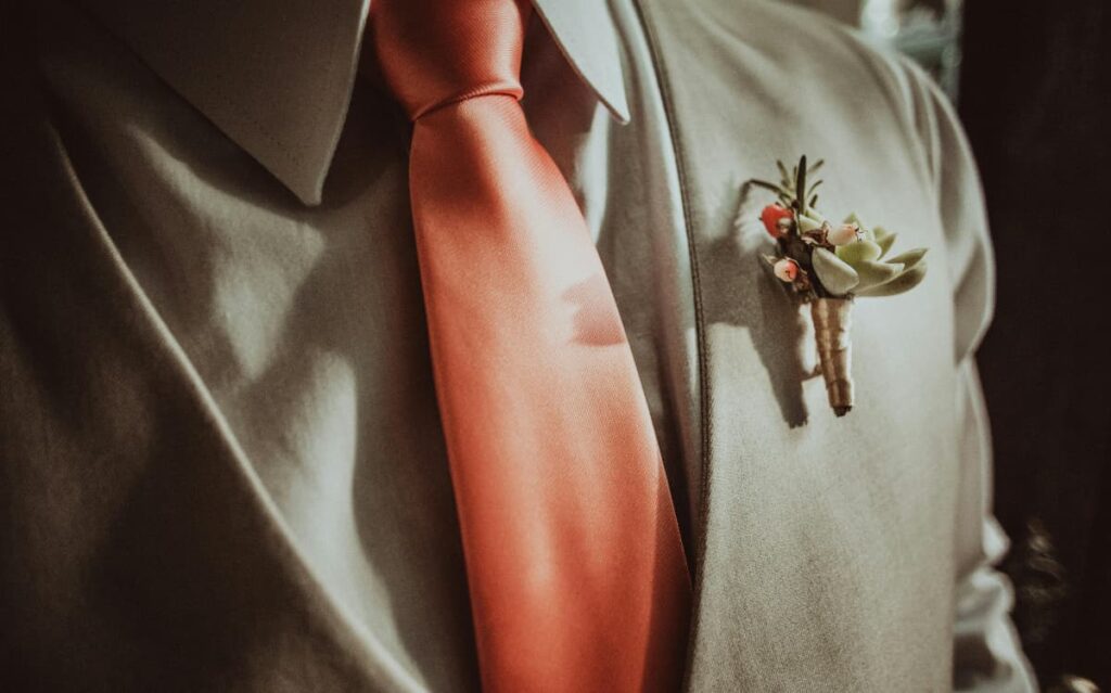 Formal attire with floral boutonniere, suggesting appropriate cruise ship dress code and attention to style details when packing.