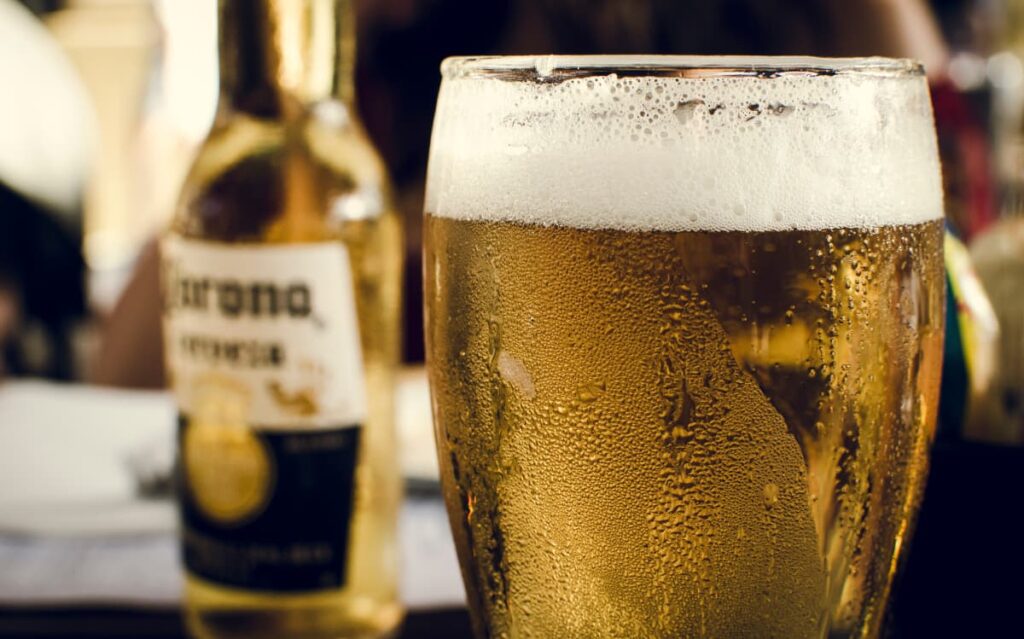 Frosty beer glass and bottle, highlighting the need for responsible alcohol consumption policies on cruise ships.