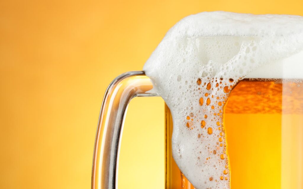 Close-up of a frothy beer mug, reminding passengers to enjoy alcoholic beverages responsibly while on the cruise.