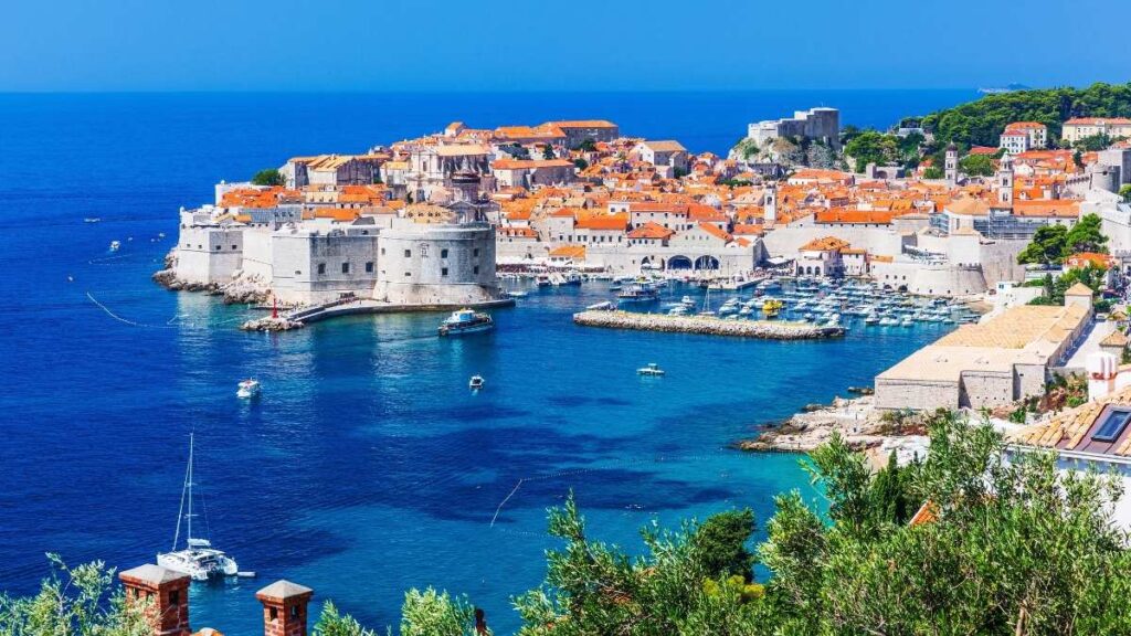 A photo of Dubrovnik in Croatia. It overlooks blue water on the coast of the town.