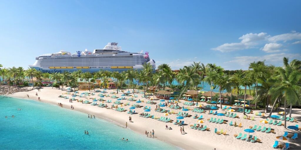 A bright, tropical beach scene at the Family Beach section of the Royal Beach Club in Nassau, showing rows of turquoise lounge chairs and umbrellas along the white sand shoreline. The large Royal Caribbean cruise ship Utopia of the Seas is docked nearby, with lush palm trees and cabanas lining the beach under a clear blue sky.