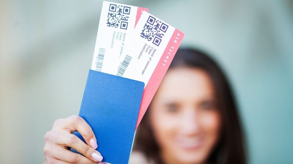 A person holding up tickets in their hand.