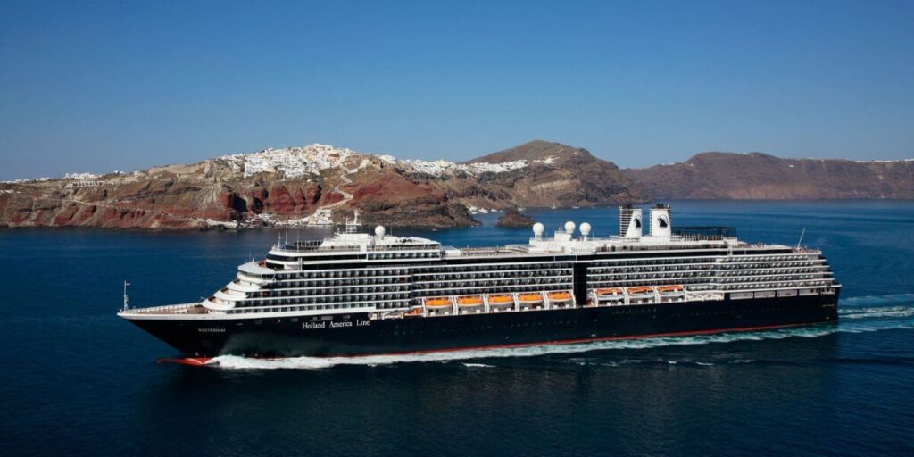 A photo of the MS Westerdam, Holland America cruise ship, sailing on the sea, with mountains in the distance.