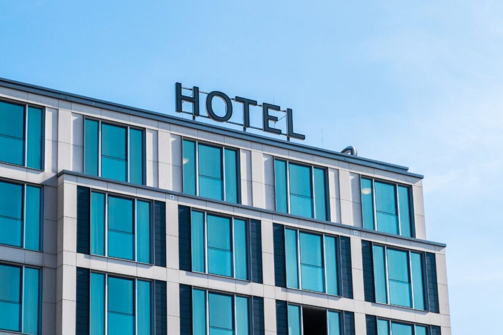 A big hotel with a small hotel signage on top of it