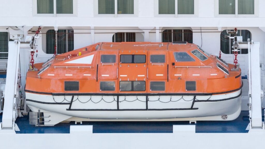 A photo of a large orange lifeboat on a cruise ship.