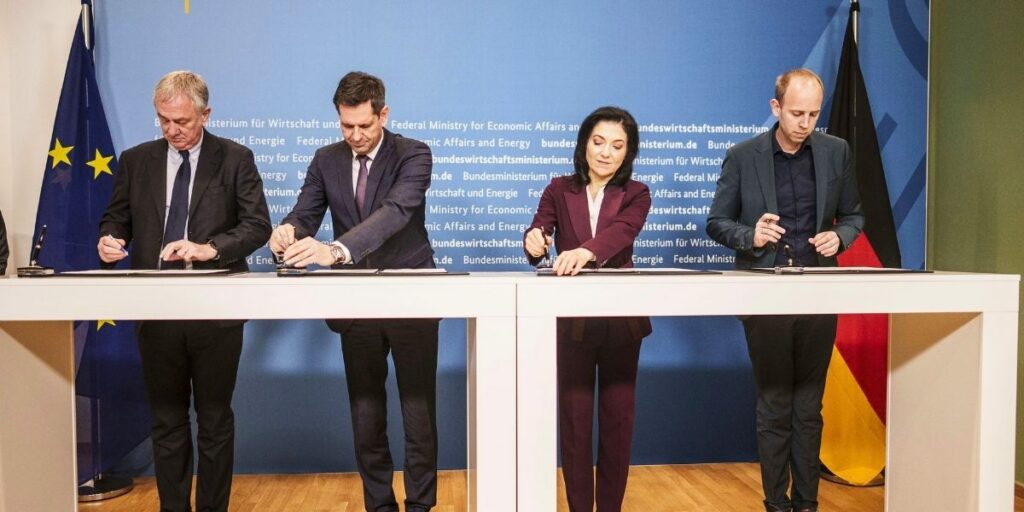 MSC Cruises and Meyer Werft executives, alongside German government officials, sign a shipbuilding agreement at a formal ceremony in Berlin, with German and EU flags visible in the background.
