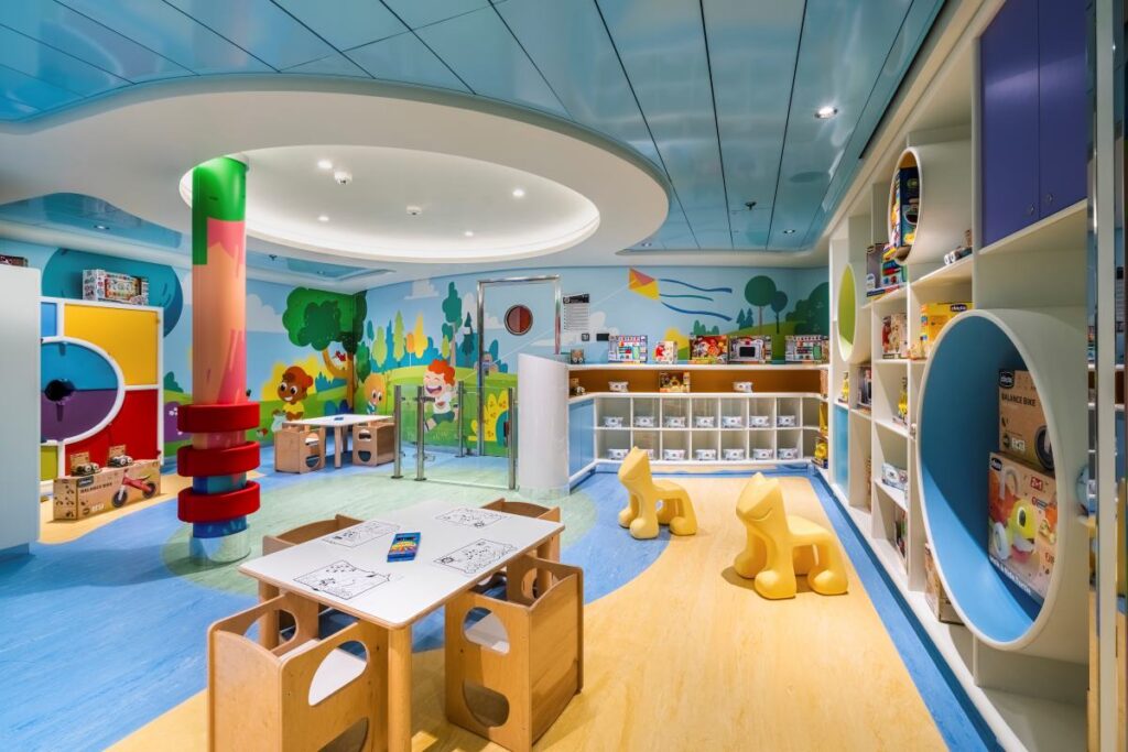 The Baby's Club on MSC Euribia offers a playful and safe environment for young children, featuring bright, cheerful murals, a variety of toys and games neatly organized on shelves, and child-sized tables and chairs for creative activities.