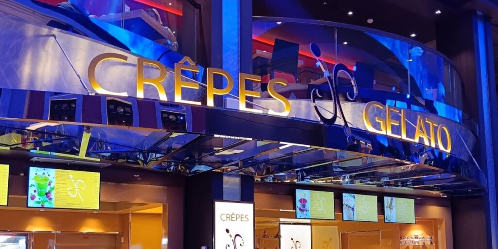 A vibrant storefront for 'Crêpes & Gelato' featuring bold illuminated signage. Below the sign, digital menu displays present a selection of sweet treats, capturing the allure of a dessert station with a contemporary design.