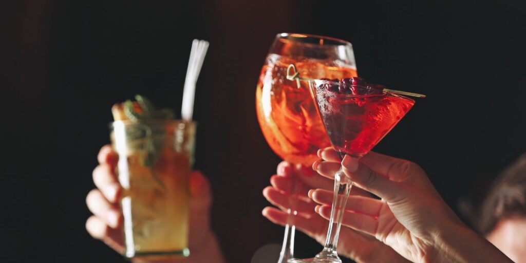 A close up image of drinks being held by different people for  a toast