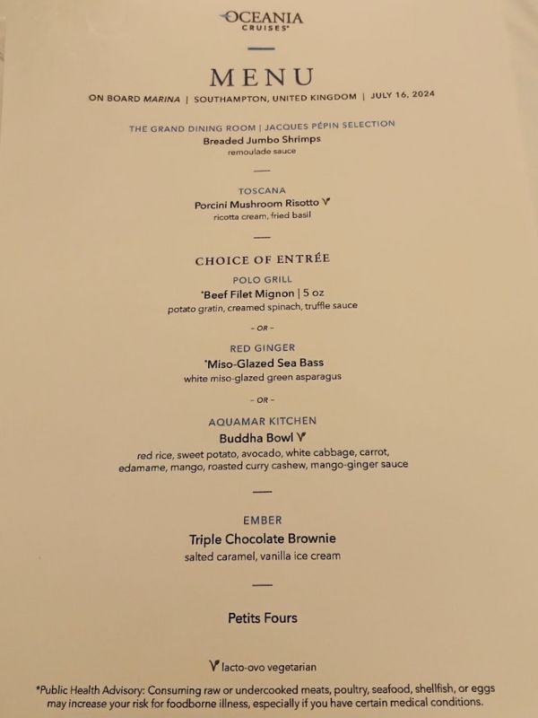 The image displays an Oceania Cruises menu for a dining experience on board Marina, dated July 16, 2024, departing from Southampton, United Kingdom. The menu includes selections from the Grand Dining Room, Jacques Pépin Selection, and offers dishes such as Breaded Jumbo Shrimps with remoulade sauce. Other options include Porcini Mushroom Risotto from Toscana, Beef Filet Mignon from Polo Grill, Miso-Glazed Sea Bass from Red Ginger, and a Buddha Bowl from Aquamar Kitchen. Dessert choices feature a Triple Chocolate Brownie with salted caramel and vanilla ice cream, followed by Petits Fours.