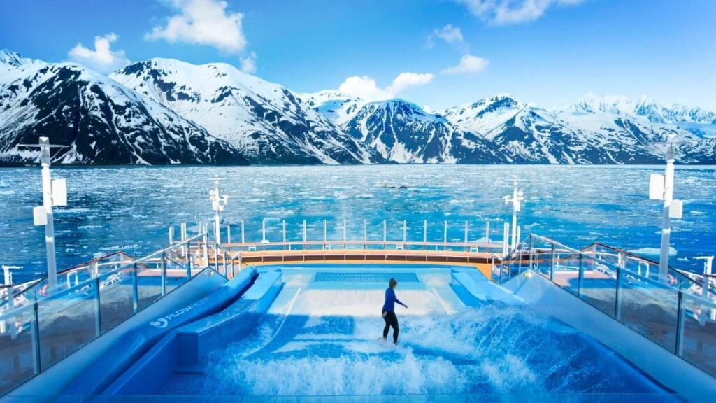 Ovation of the Seas in Alaska, showing someone on the Flowrider on the back of the ship.