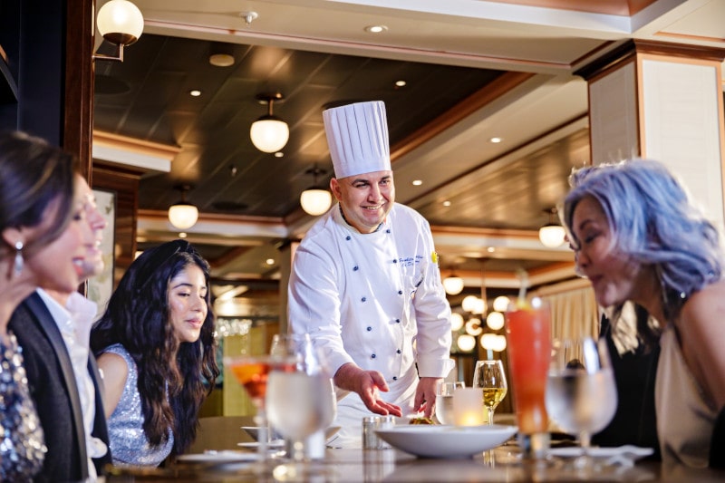A chef at a table serving on the Discovery Princess