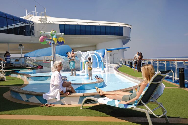 Families enjoying the Reef Family Splash Zone on a Princess Cruises ship while adults relax nearby.