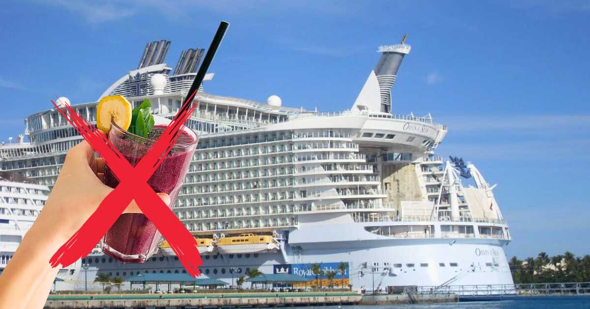 This image shows a Royal Caribbean cruise ship in port under a bright blue sky. In the foreground, a hand holding a cocktail with a garnish is crossed out with a bold red "X," suggesting not having a drink.