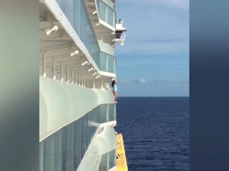 Someone standing on the edge of a balcony on Allure of the Seas