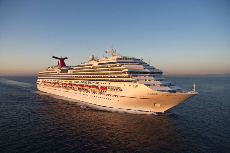 In the warm glow of sunset, the Carnival Splendor cruise ship journeys across the calm sea, its distinctive red funnel marking a striking contrast against the serene twilight sky.