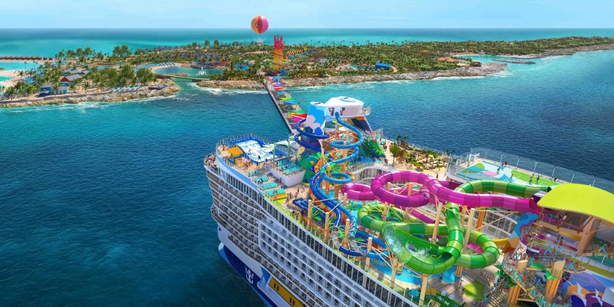 Star of the Seas decked out with colorful water slides, pools, and lounging areas is docked at a lush tropical island. A winding pier connects the ship to the island labeled "Perfect Day at CocoCay," featuring palm trees, beach cabanas, and a red-and-yellow water tower in the distance, with a tethered helium balloon floating above.
