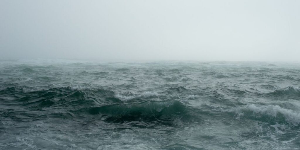 Misty and tumultuous, the waters of the Bay of Biscay are captured in their moody unrest, with waves rolling under a shrouded, overcast sky. This image evokes the unpredictable nature that sailors and travelers may face in this notorious stretch of sea.