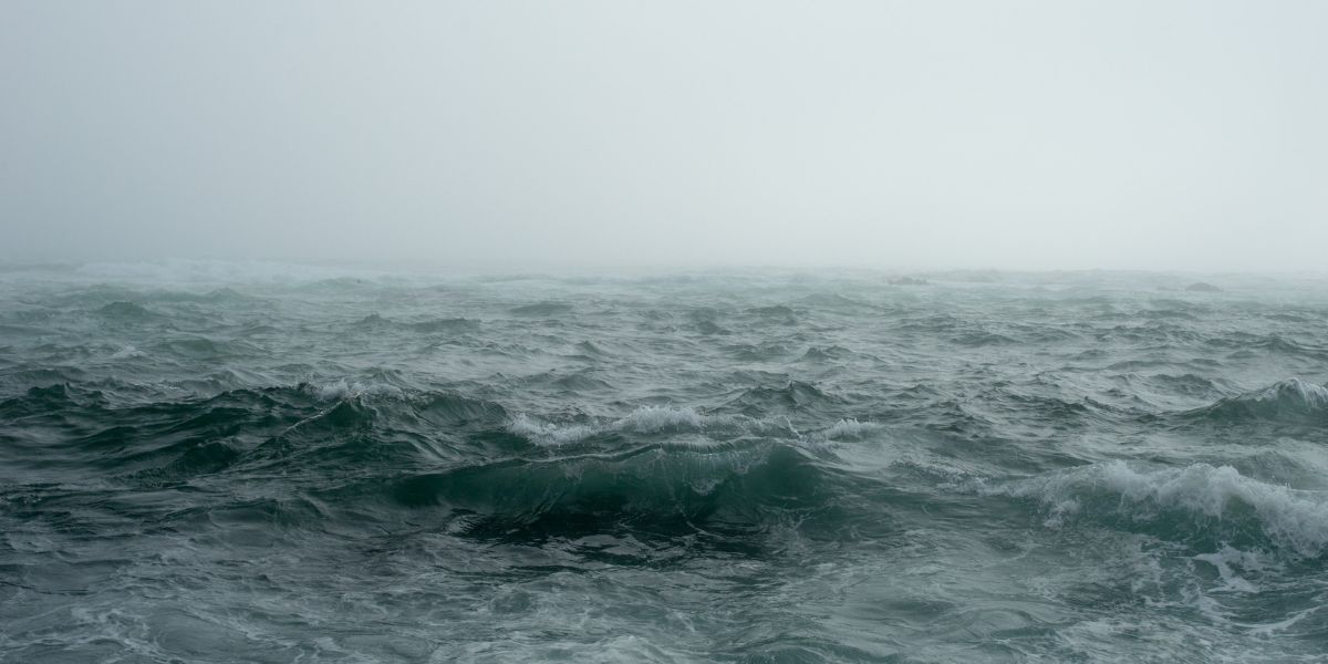Misty and tumultuous, the waters of the Bay of Biscay are captured in their moody unrest, with waves rolling under a shrouded, overcast sky. This image evokes the unpredictable nature that sailors and travelers may face in this notorious stretch of sea.