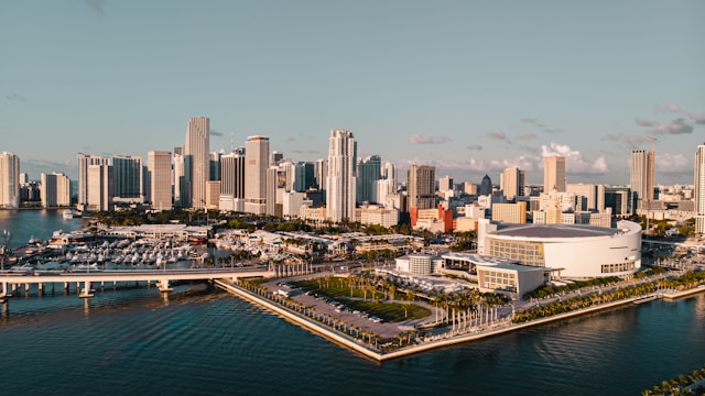 Aerial view of downtown Miami’s waterfront skyline with high-rise buildings, a marina, and the arena along Biscayne Bay.