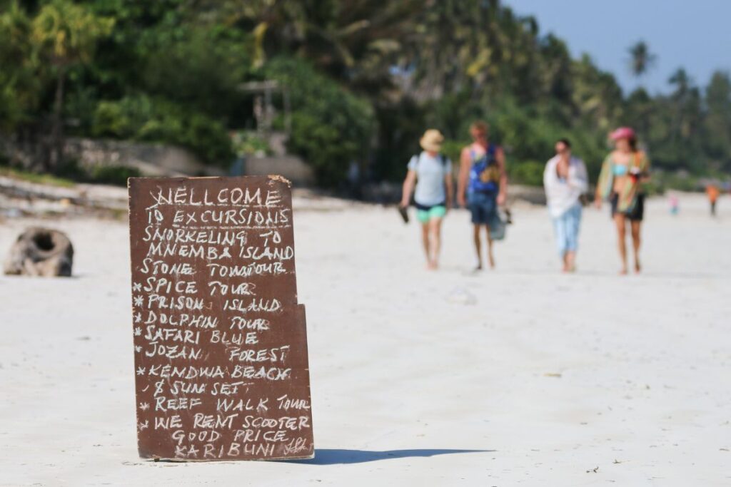 List of Shore Excursions with the cruise passenger walking on the sand behind it