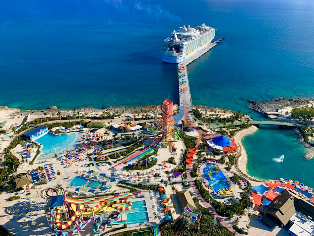 Aerial view of a cruise ship docked at  the CocoCay private island in the Bahamas with colorful water slides, pools, and a lagoon.
