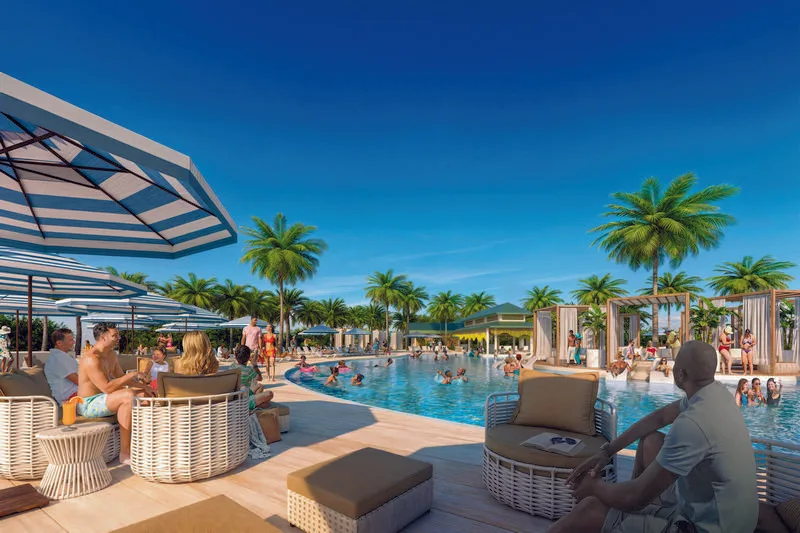 A tropical resort style pool at Isla Tropicale with cabanas, umbrellas, palm trees and cruise guests relaxing in the sun.